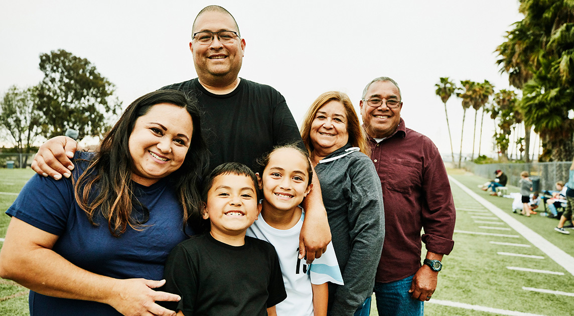   A multi-generational family of Covered California members smiles in their  front yard.